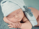 Photo nouveau-ne Photo couleur de bébé endormi sur ses bras