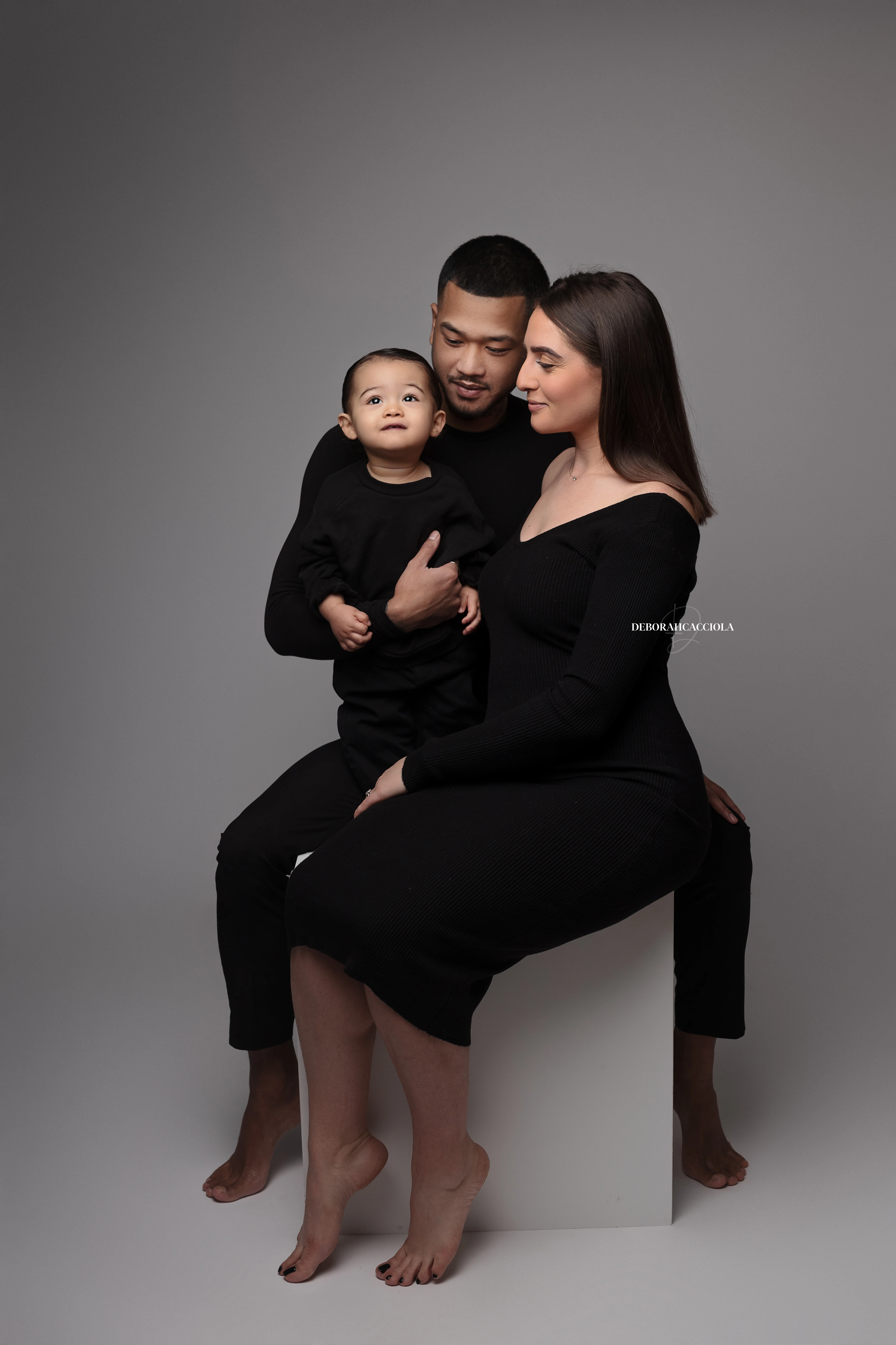family session in studio in Orléans, France: connected family moment, elegant close composition, monochrome look