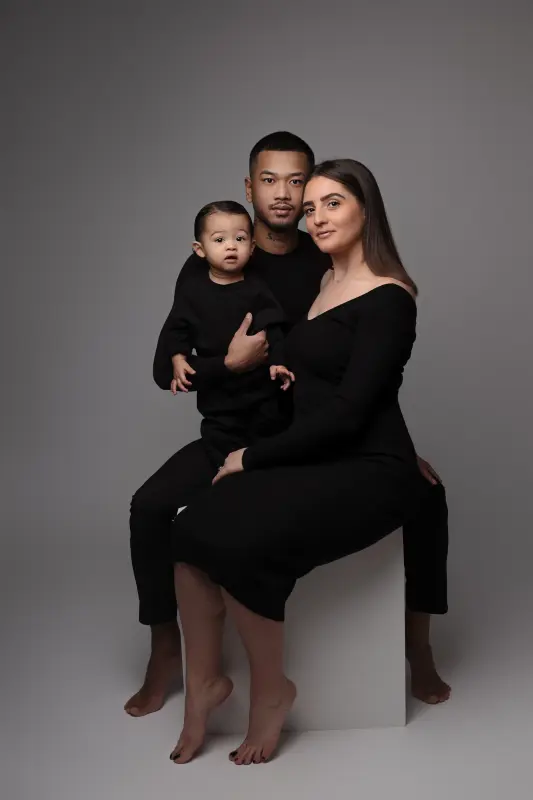 family session in studio in Orléans, France: family together, soft vertical framing, polished black-and-white treatment