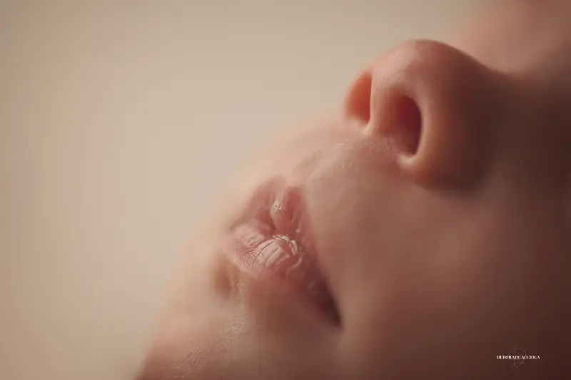 newborn portrait in Orléans, France: tender moment with baby, harmonious wide shot, light palette