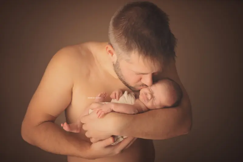newborn portrait in Orléans, France: tender moment with baby, harmonious wide shot, soft colors