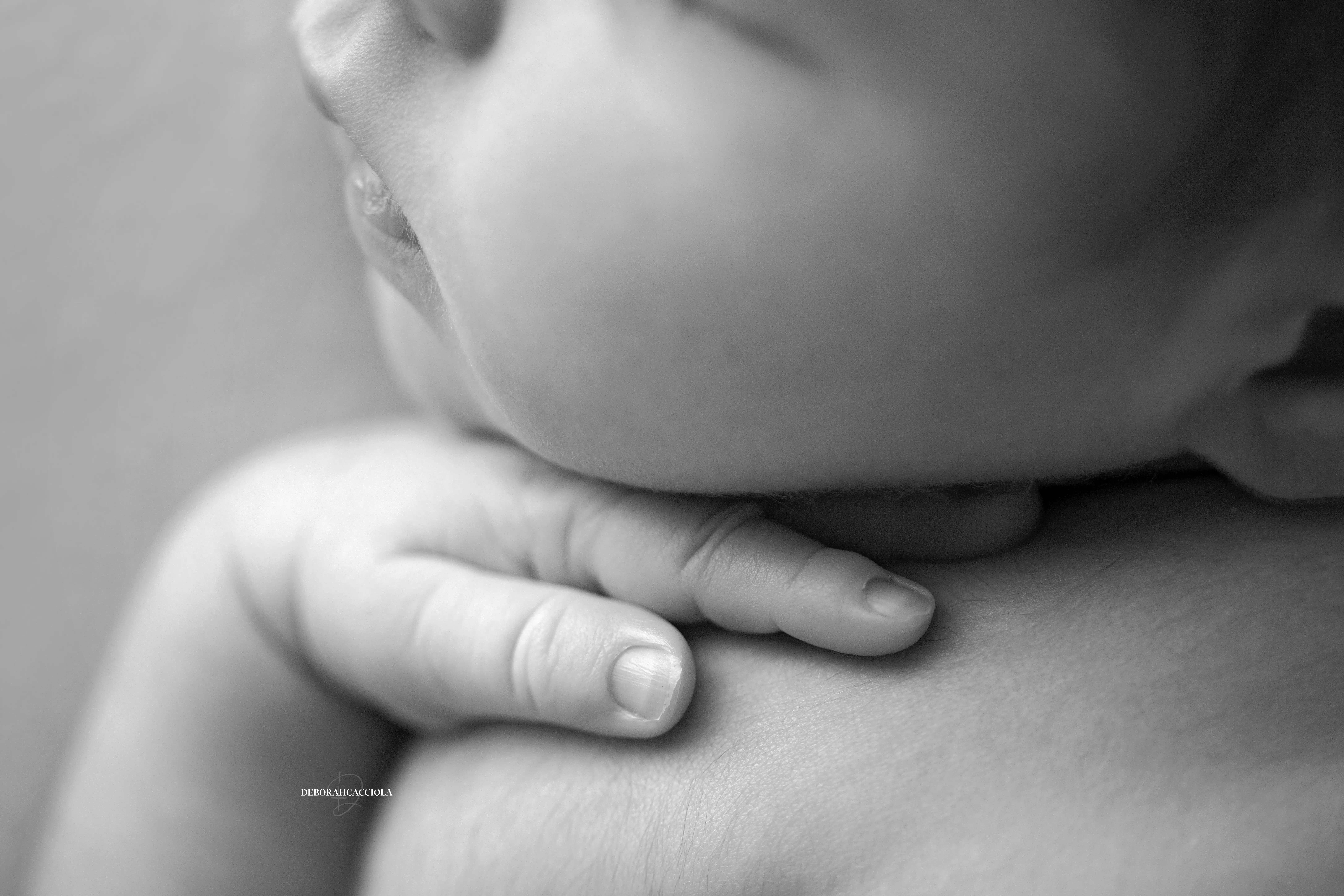newborn portrait in Orléans, France: tender moment with baby, harmonious wide shot, black-and-white contrast