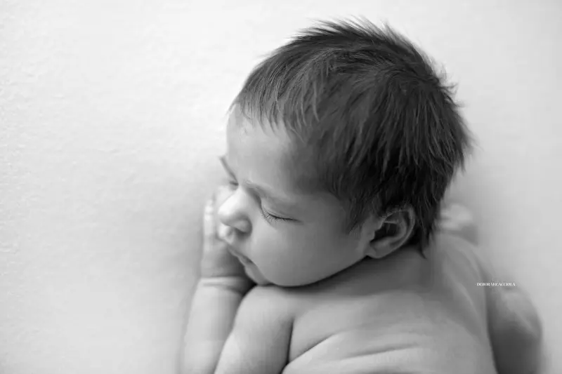newborn portrait in Orléans, France: tender moment with baby, harmonious wide shot, black-and-white contrast