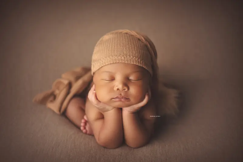 newborn portrait in Orléans, France: tender moment with baby, harmonious wide shot, light palette