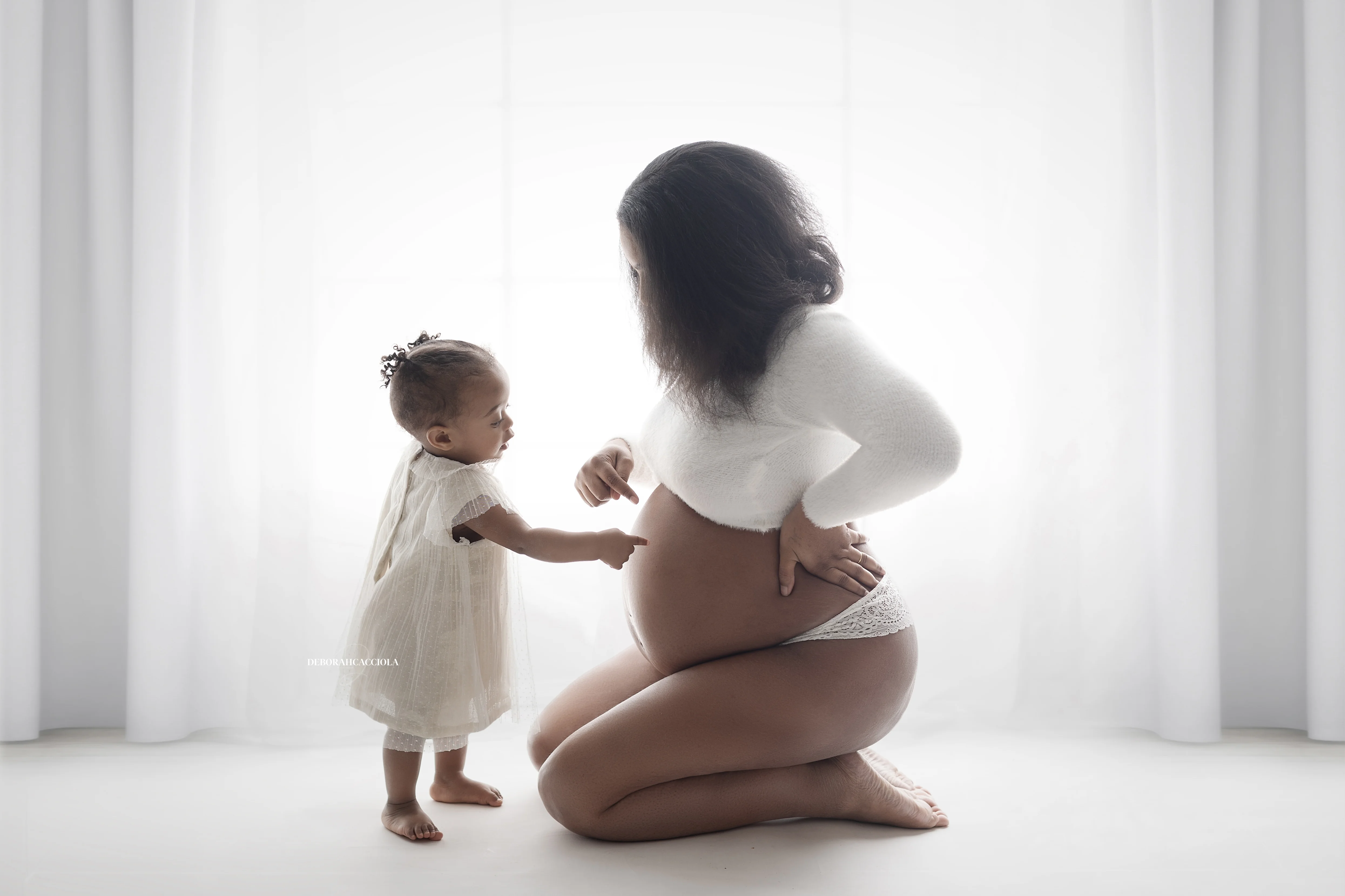 pregnancy session in studio in Orléans, France: mother-to-be, balanced horizontal framing, black-and-white style