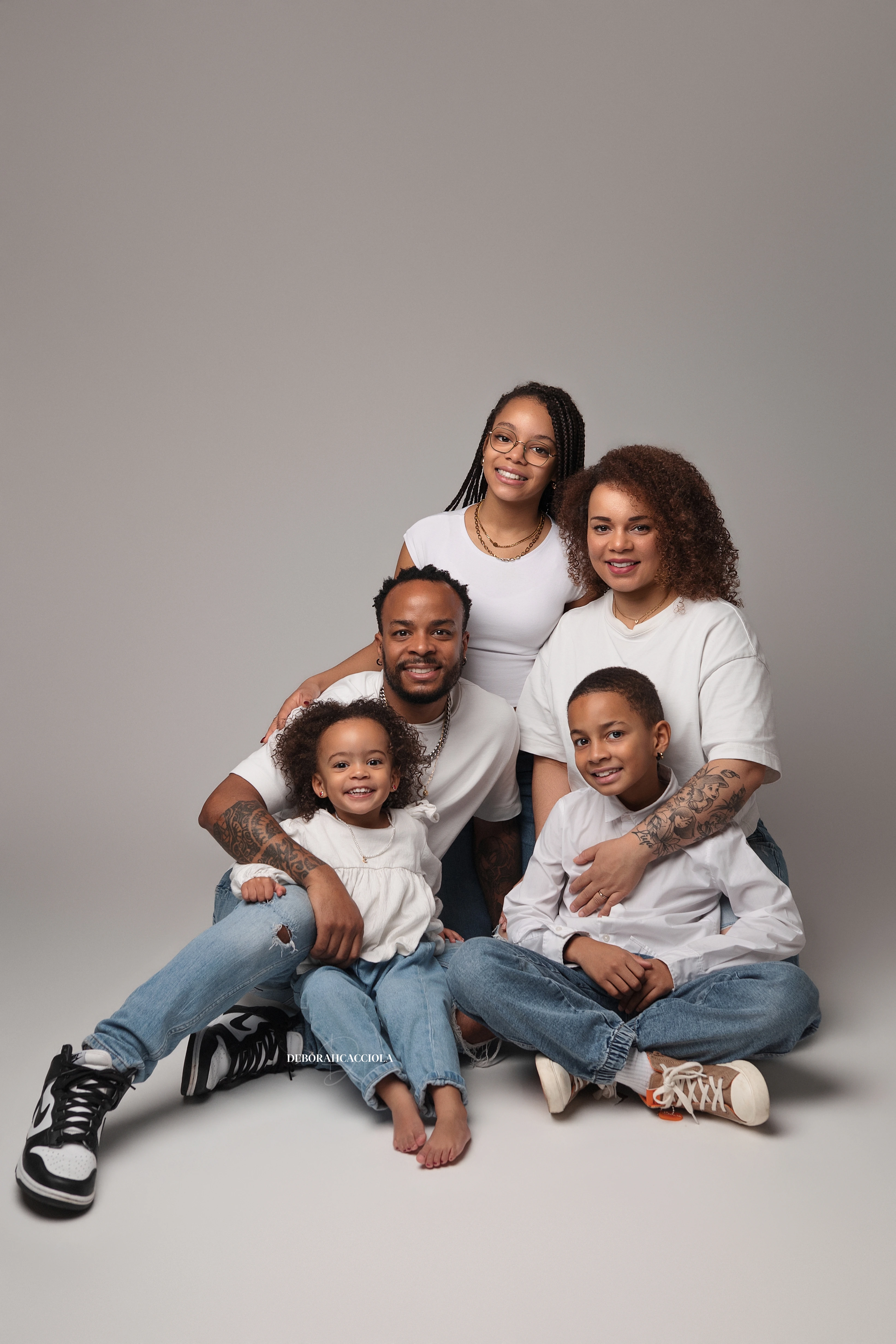 sesión familiar en estudio en Orléans, Francia: familia reunida, encuadre vertical suave, resultado natural