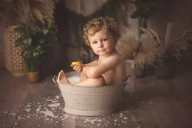 Bébé qui joue dans un bain de lait pendant la séance anniversaire