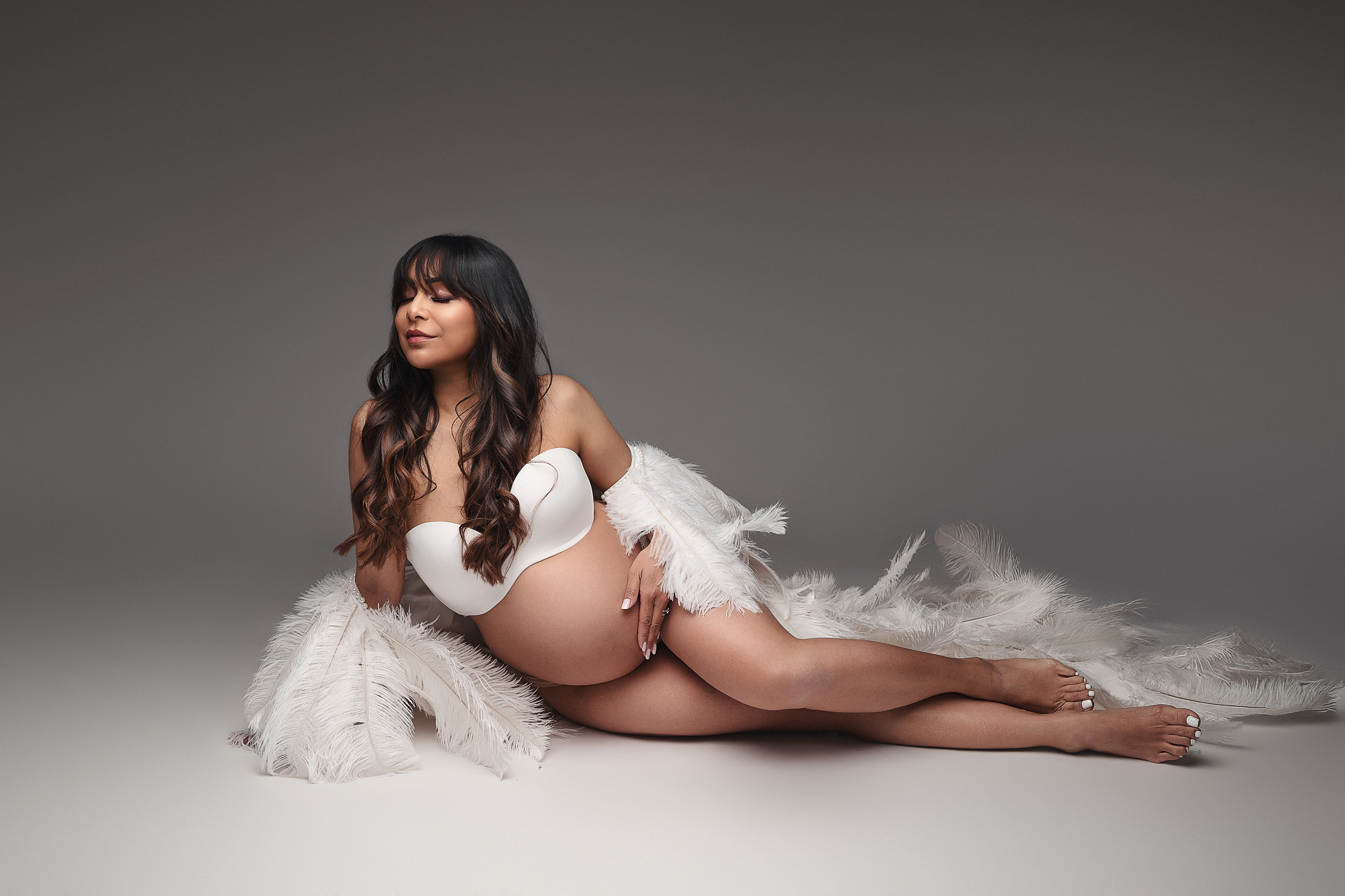 Pose guidée pendant une séance photo grossesse en studio