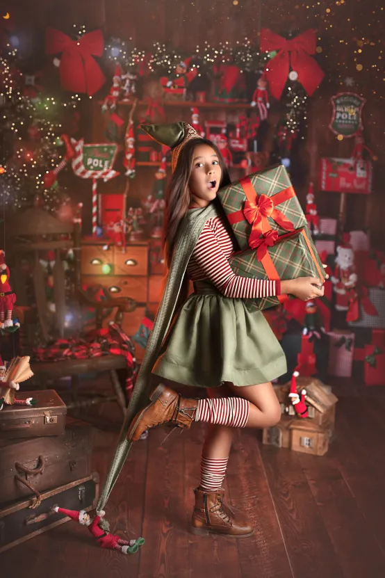 Jeune fille en tenue de lutin dans le décor de Noël du studio