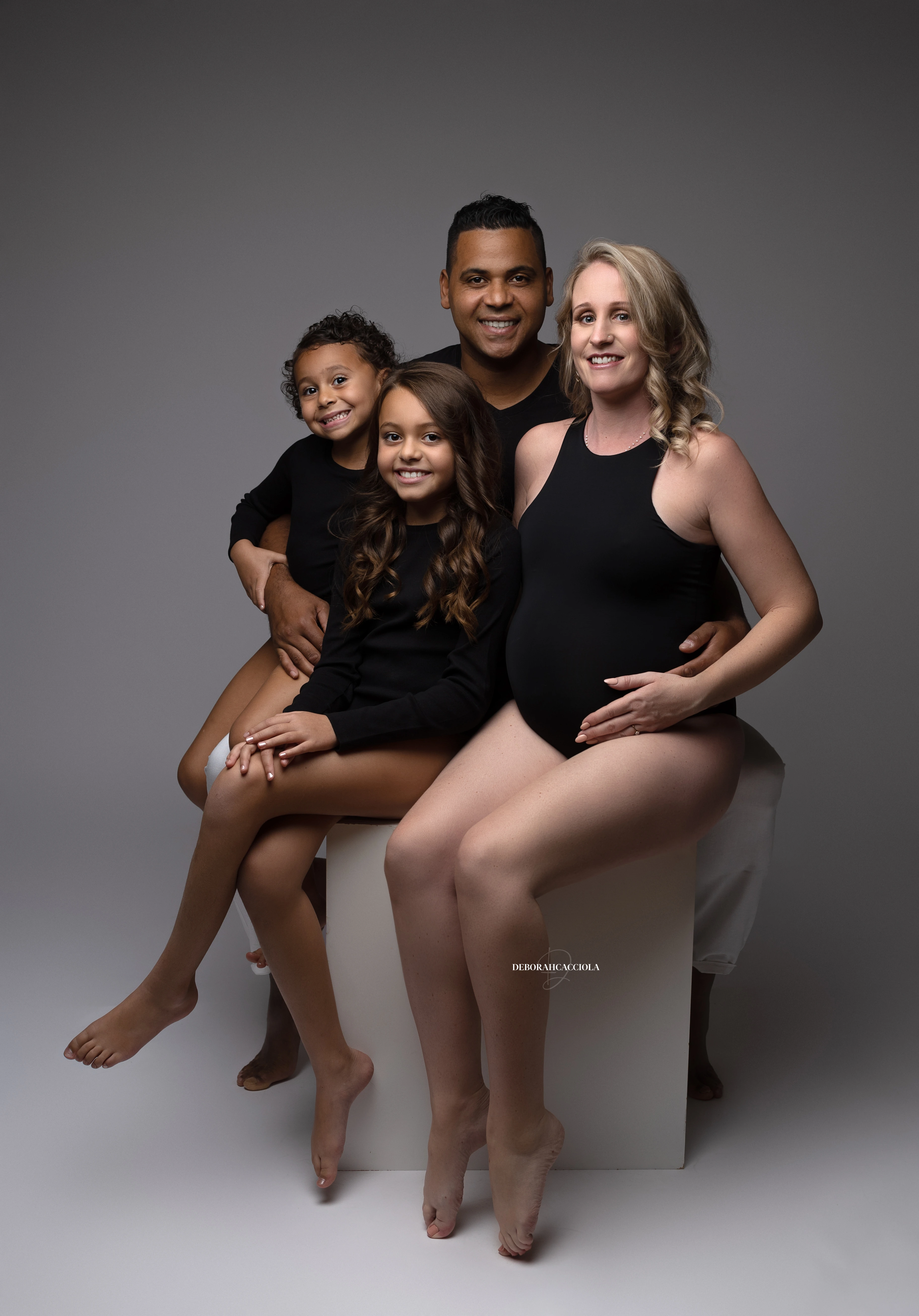 Photo famille studio Orléans : moment complice en famille, composition resserrée élégante, couleurs équilibrées