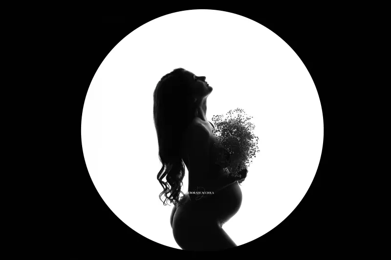 Scène grossesse en studio à Orléans : femme enceinte, composition large et naturelle, style noir et blanc