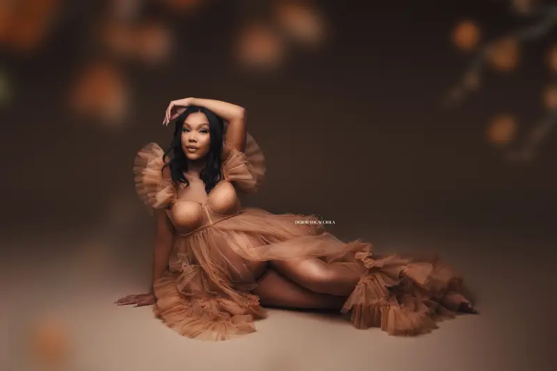 Scène grossesse à Orléans, future maman en séance studio, plan large harmonieux, couleurs naturelles