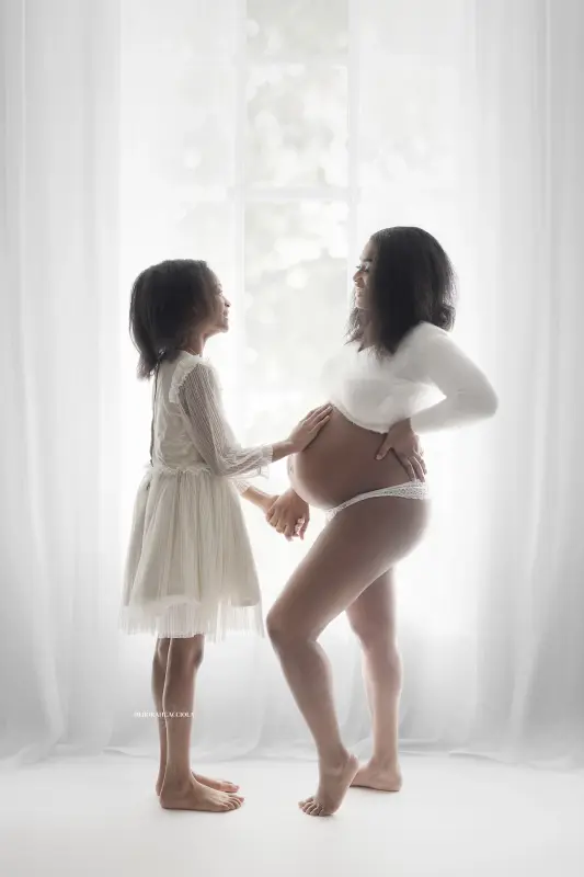 Portrait grossesse à Orléans : future maman en séance studio, cadrage vertical doux, style monochrome