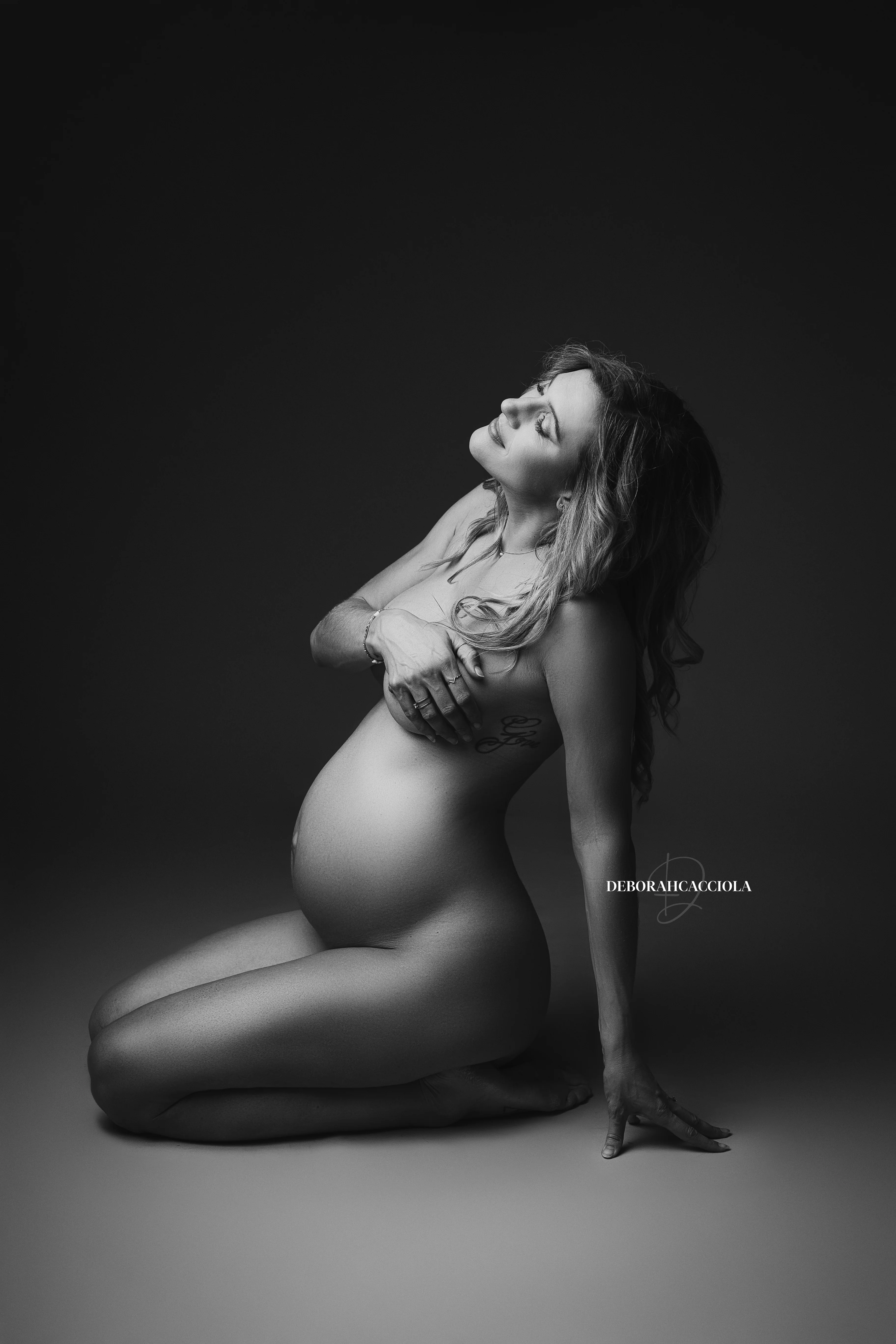 Photo grossesse en studio à Orléans : femme enceinte, plan vertical élégant, style noir et blanc