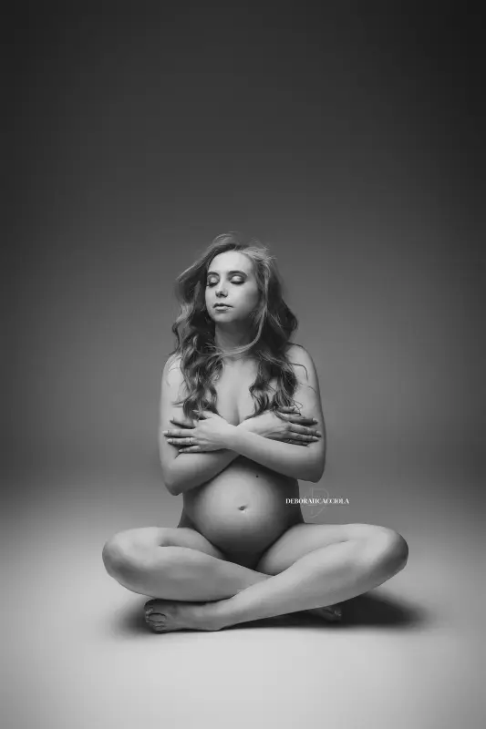 Photo grossesse à Orléans : future maman en séance studio, cadrage vertical doux, style monochrome