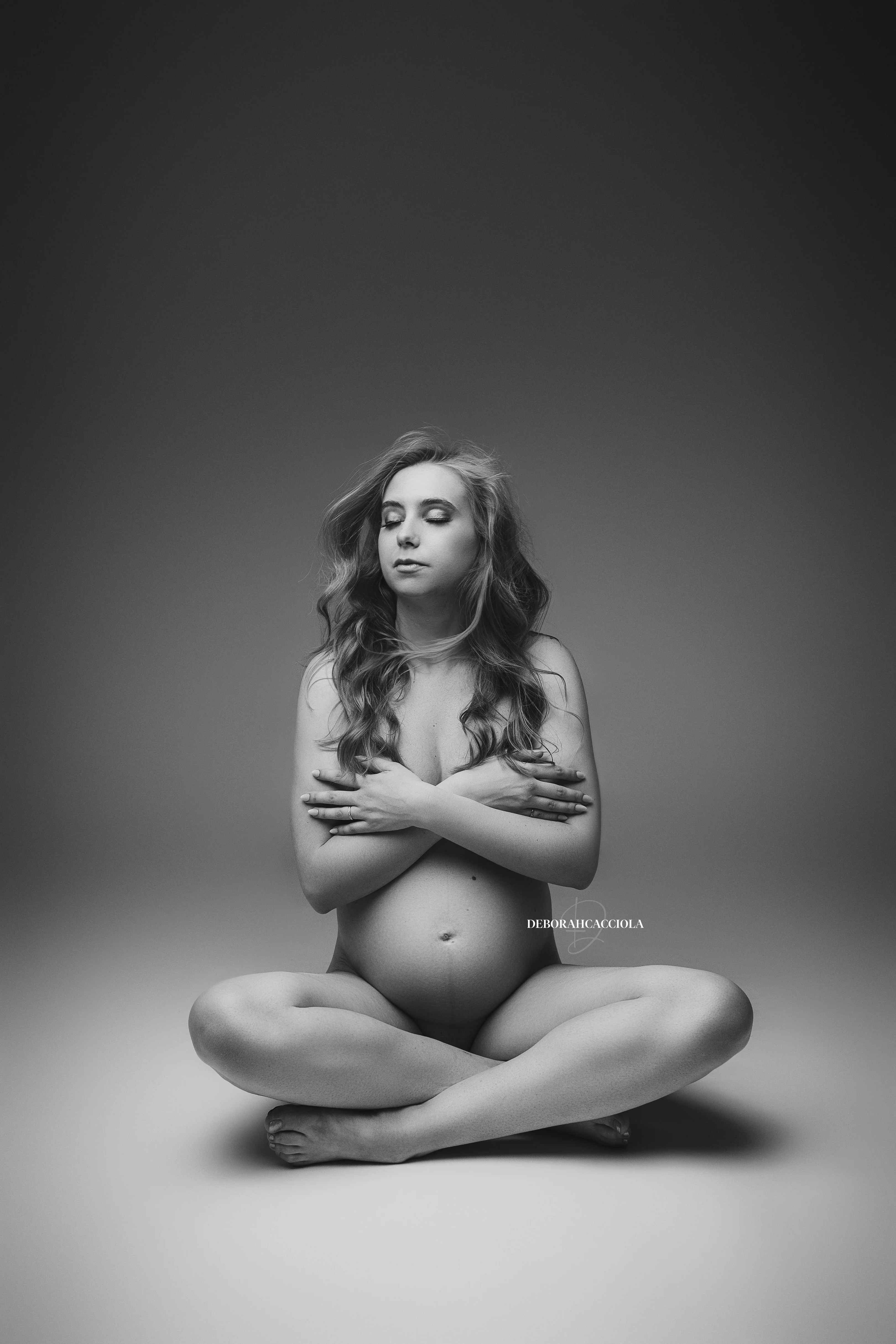 Photo grossesse à Orléans : future maman en séance studio, cadrage vertical doux, style monochrome