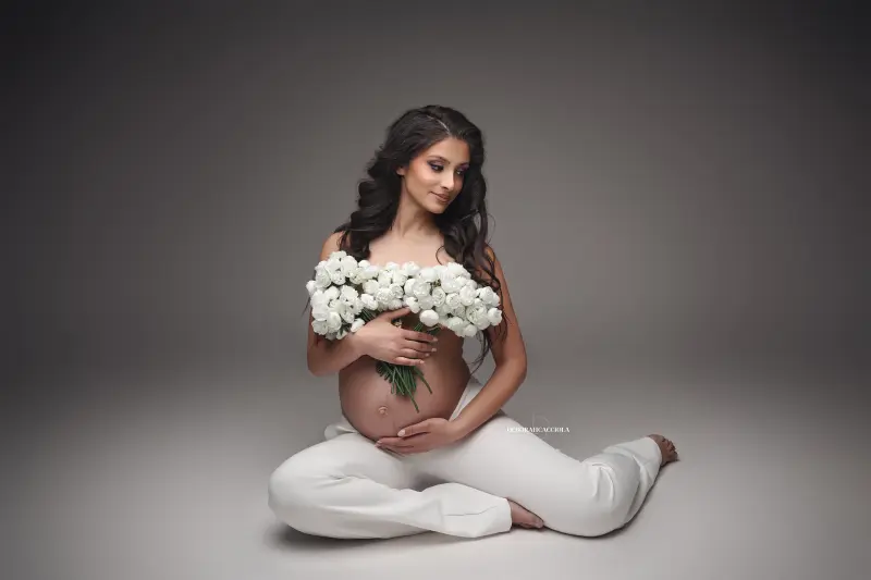 Scène grossesse à Orléans : future maman en séance studio, plan large harmonieux, couleurs naturelles