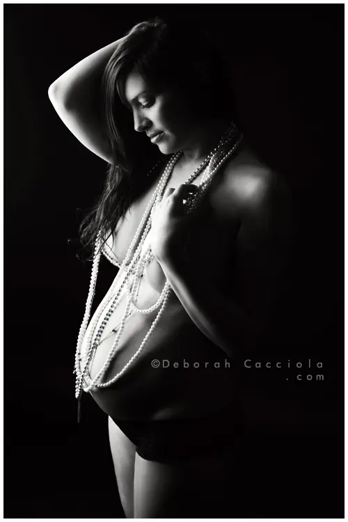 Photo grossesse en studio à Orléans : future maman en séance studio, cadrage vertical doux, style noir et blanc