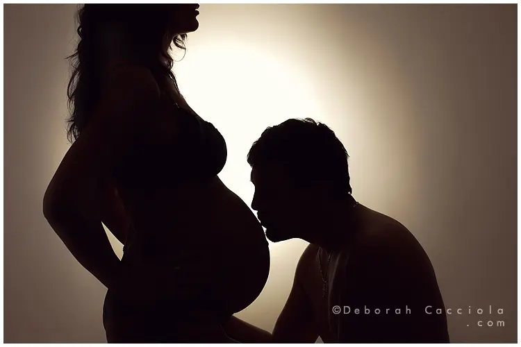 Photo grossesse en studio à Orléans : futurs parents complices, cadrage horizontal équilibré, palette douce