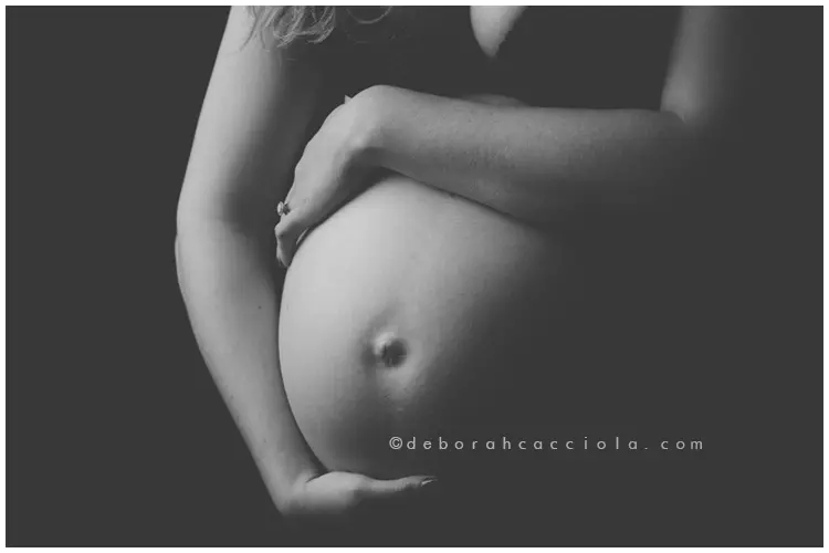 Scène grossesse en studio à Orléans : future maman en séance studio, plan large harmonieux, style noir et blanc