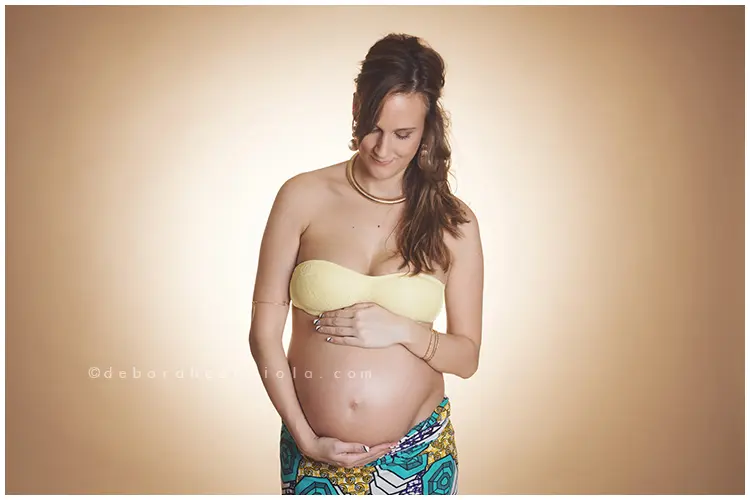 Scène grossesse en studio à Orléans : future maman en séance studio, plan large harmonieux, couleurs naturelles