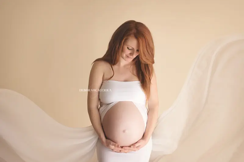 Séance grossesse en studio à Orléans : silhouette de maternité, mise en scène horizontale douce, rendu clair et naturel