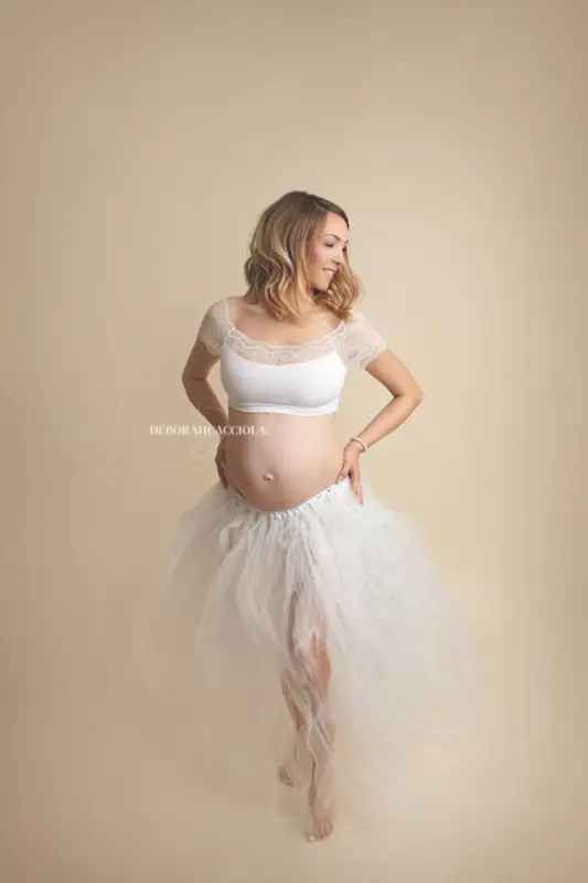 Photo grossesse en studio à Orléans : future maman en séance studio, cadrage vertical doux, couleurs naturelles