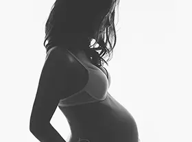 Photo grossesse à Orléans : future maman en séance studio, plan large harmonieux, style monochrome