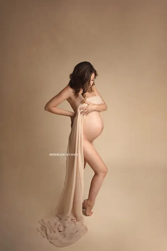 Portrait maternité en studio à Orléans : future maman en séance studio, cadrage vertical doux, style lumineux