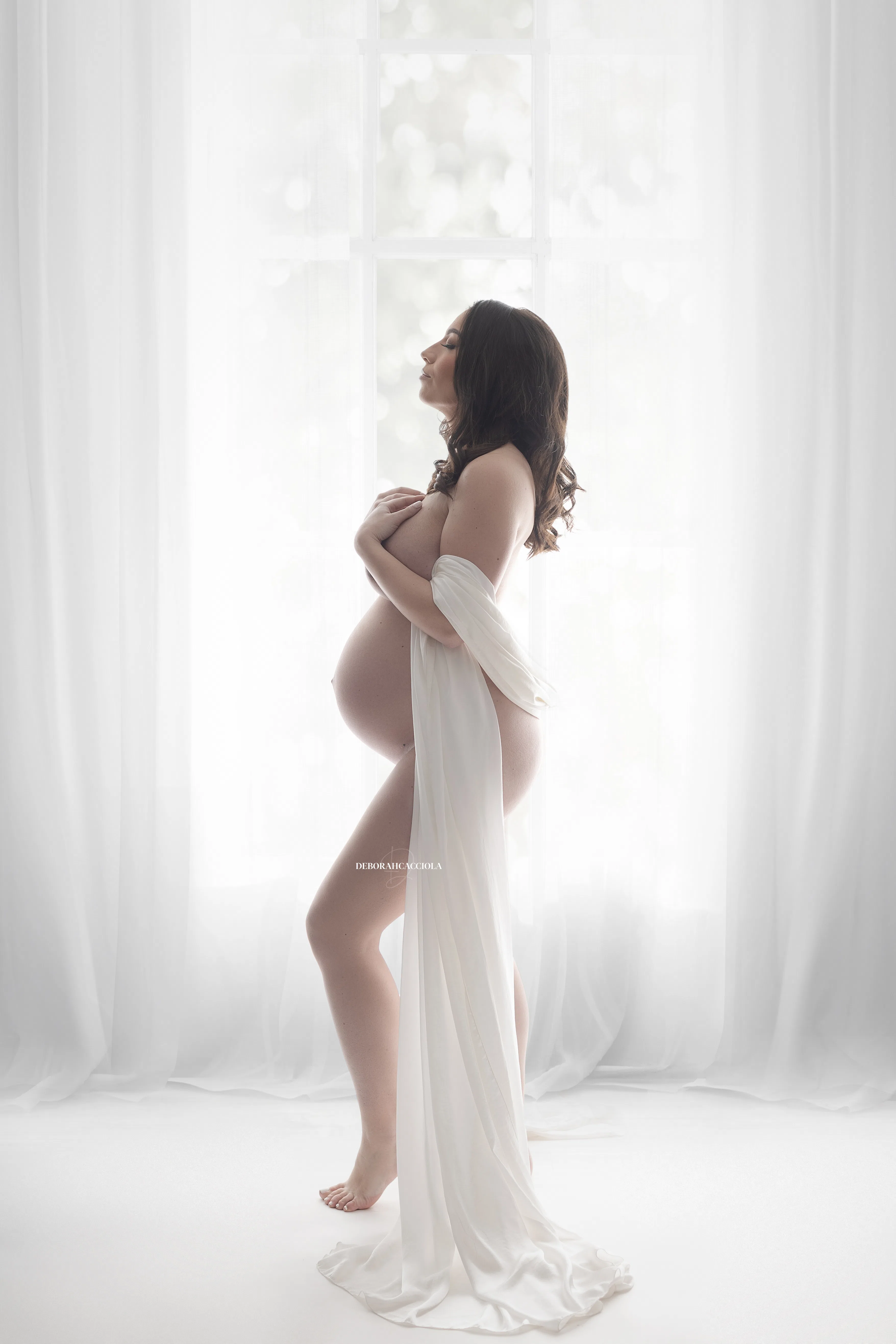 Photo grossesse à Orléans : future maman en séance studio, cadrage vertical doux, style monochrome