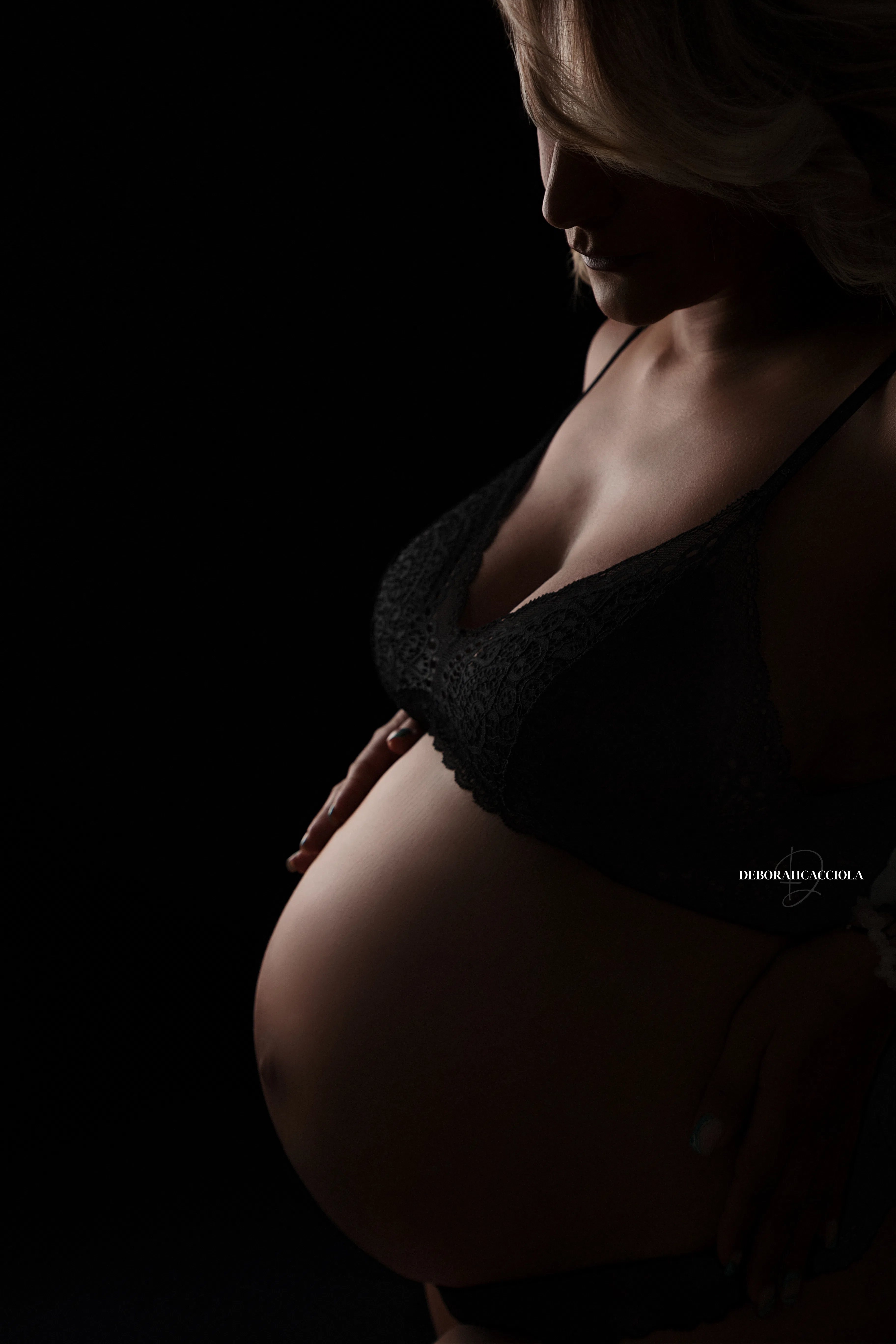 Portrait grossesse grossesse à Orléans, future maman en séance studio, cadrage vertical doux, traitement monochrome élégant