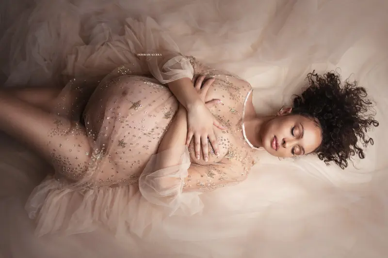 Scène grossesse en studio à Orléans : maternité naturelle, mise en scène horizontale douce, tonalités naturelles