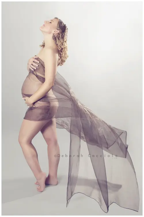 Photo grossesse en studio à Orléans : silhouette de maternité, portrait vertical soigné, tonalités naturelles