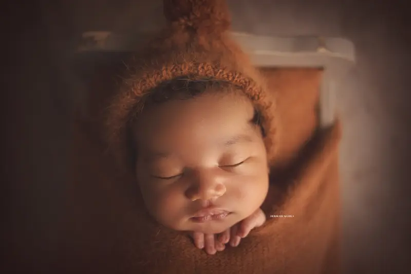Photo nouveau-né studio Orléans : portrait délicat de bébé, cadrage horizontal équilibré, tonalités naturelles