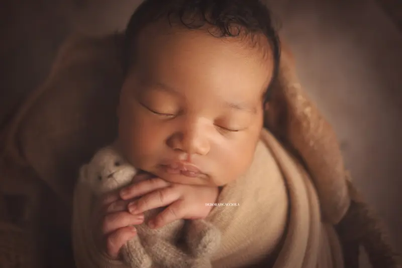 Photo nouveau-né studio Orléans : portrait délicat de bébé, cadrage horizontal équilibré, couleurs douces
