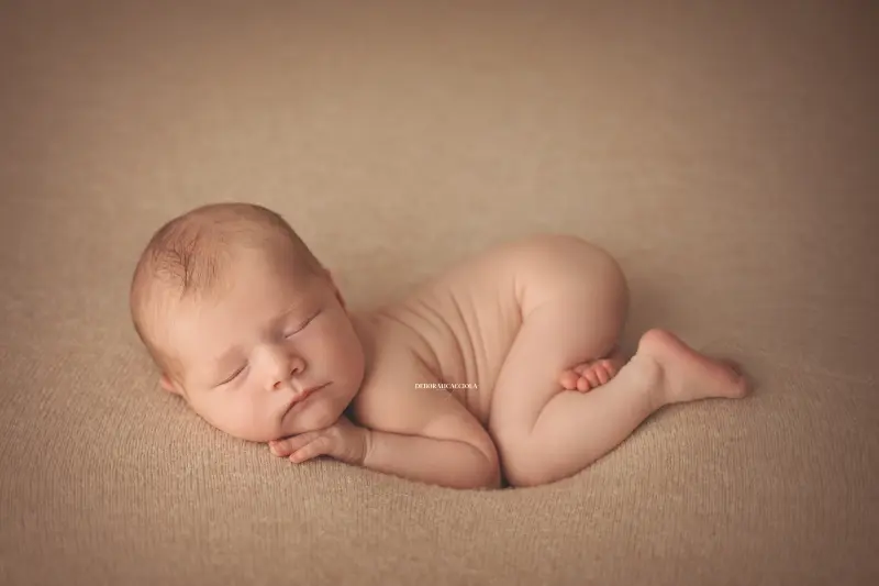 Portrait nouveau-né Orléans : nouveau-né en studio, scène panoramique douce, palette claire