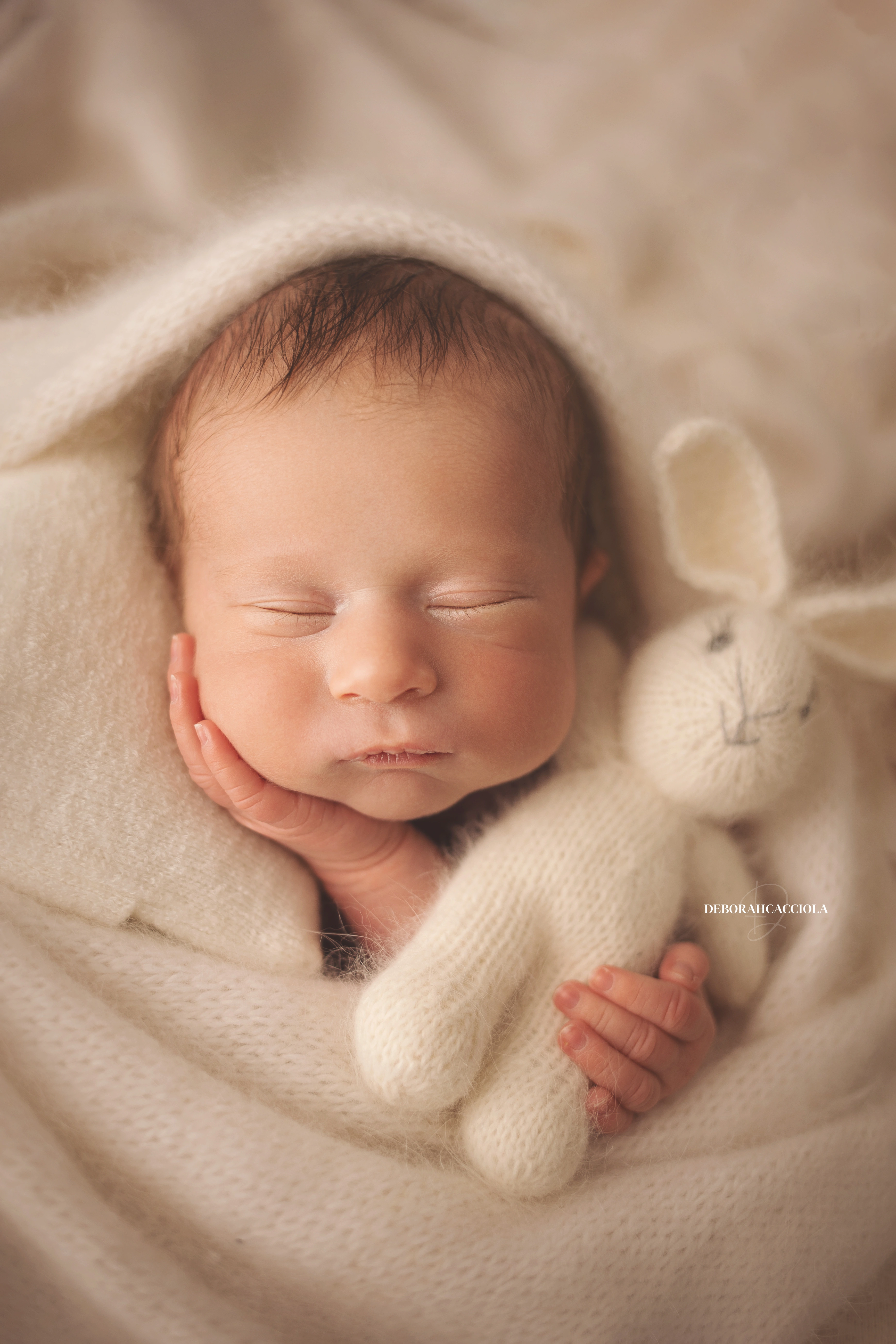 Séance bébé en studio à Orléans : portrait délicat de bébé, composition resserrée élégante, palette claire