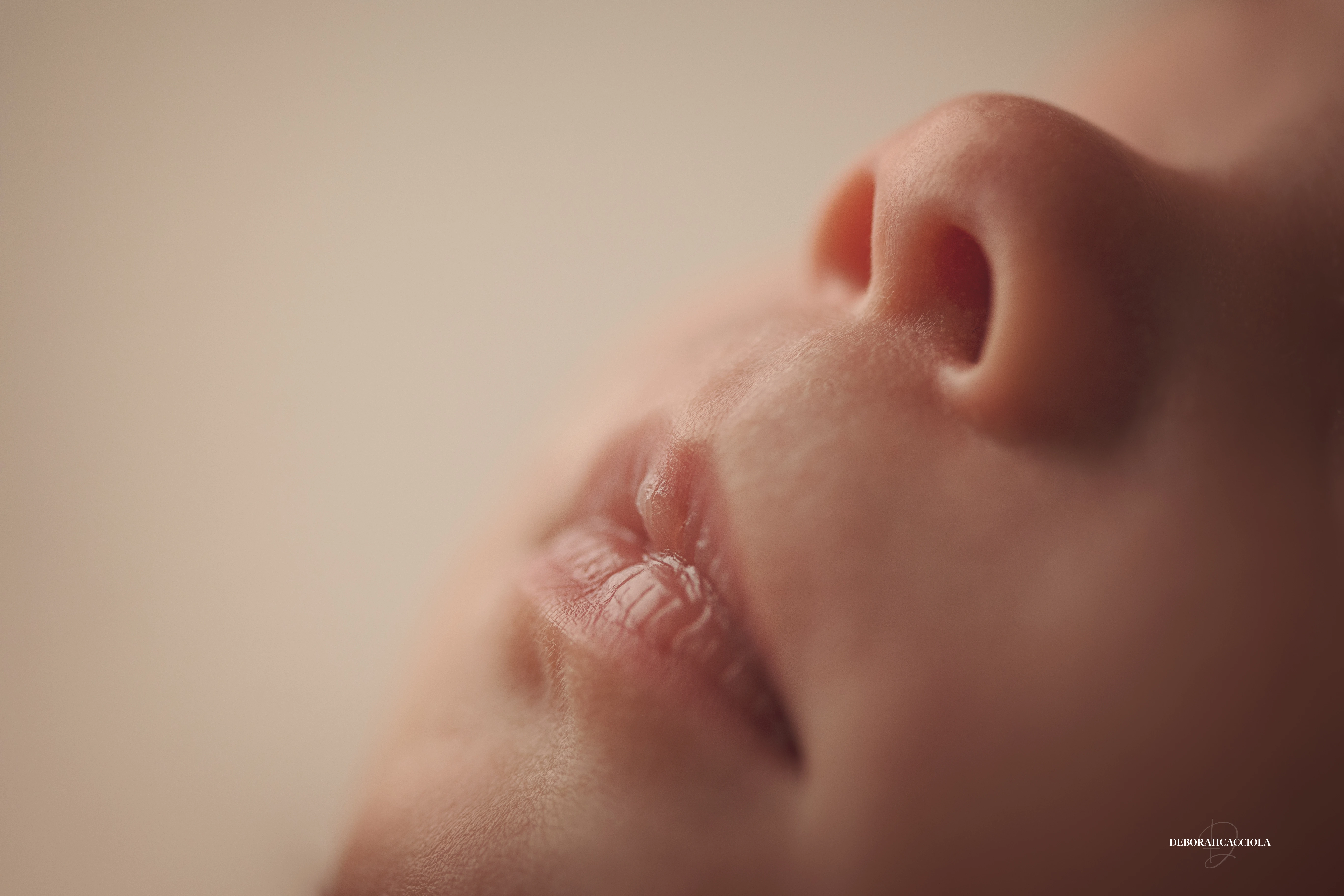 Portrait nouveau-né à Orléans : instant tendre avec bébé, plan large harmonieux, palette claire