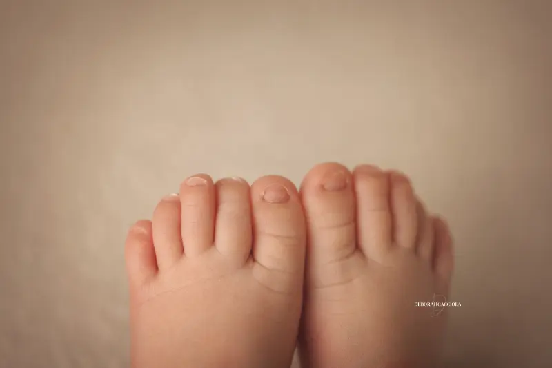 Photo nouveau-né studio Orléans : portrait délicat de bébé, cadrage horizontal équilibré, couleurs douces