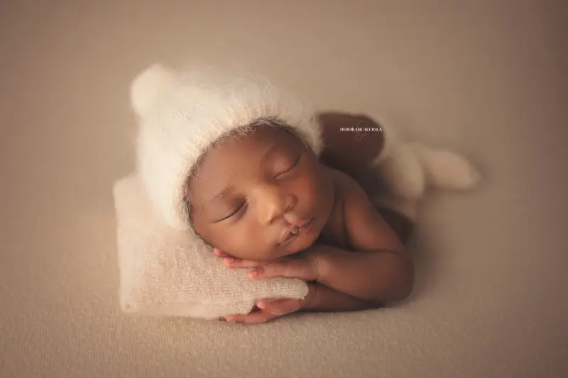 Séance bébé en studio à Orléans : portrait délicat de bébé, cadrage horizontal équilibré, couleurs douces
