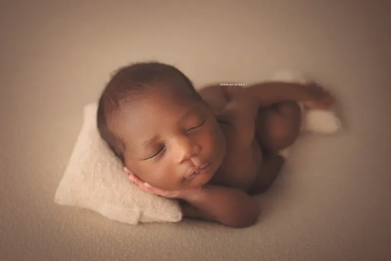 Portrait nouveau-né à Orléans : instant tendre avec bébé, plan large harmonieux, couleurs équilibrées