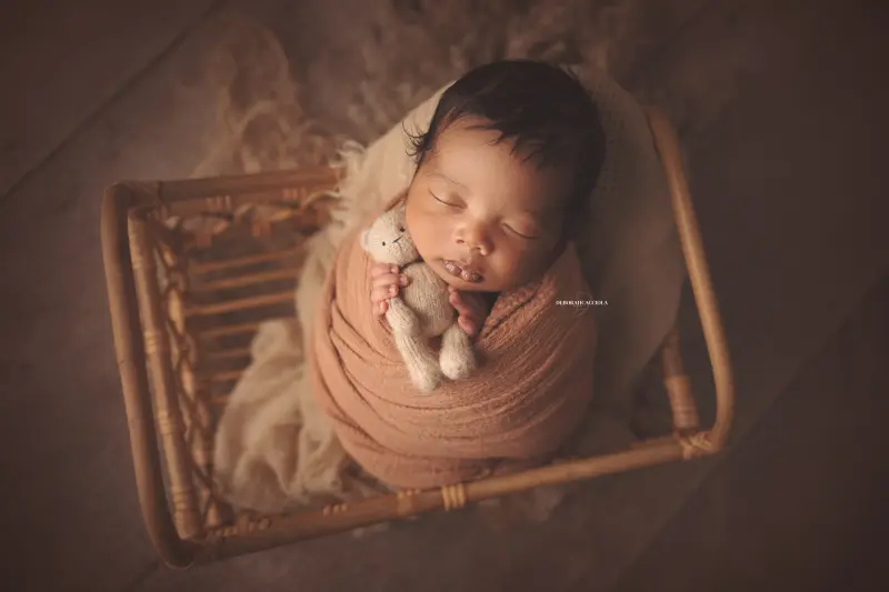 Photo nouveau-né studio Orléans : portrait délicat de bébé, cadrage horizontal équilibré, couleurs douces