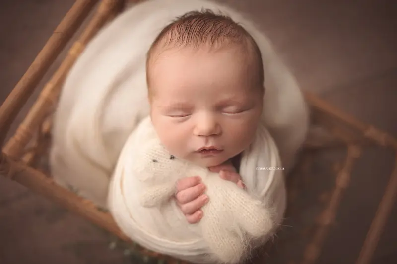 Photo nouveau-né à Orléans, instant tendre avec bébé, plan large harmonieux, couleurs équilibrées