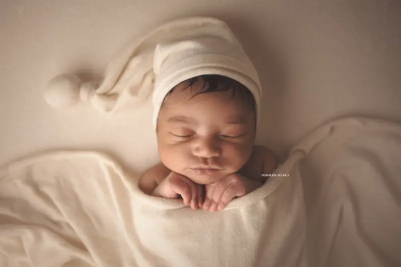 Portrait nouveau-né Orléans : nouveau-né en studio, scène panoramique douce, couleurs équilibrées