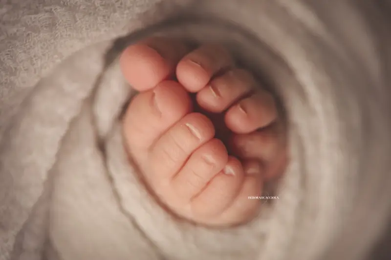 Photo nouveau-né studio Orléans : portrait délicat de bébé, cadrage horizontal équilibré, couleurs équilibrées