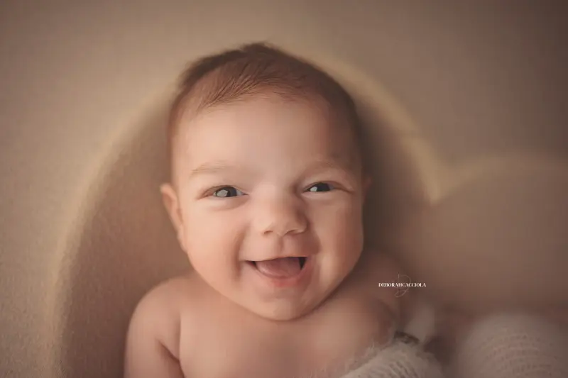 Séance bébé en studio à Orléans : portrait délicat de bébé, cadrage horizontal équilibré, palette claire
