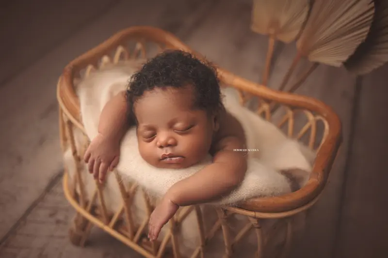 Photo nouveau-né studio Orléans : portrait délicat de bébé, cadrage horizontal équilibré, palette claire