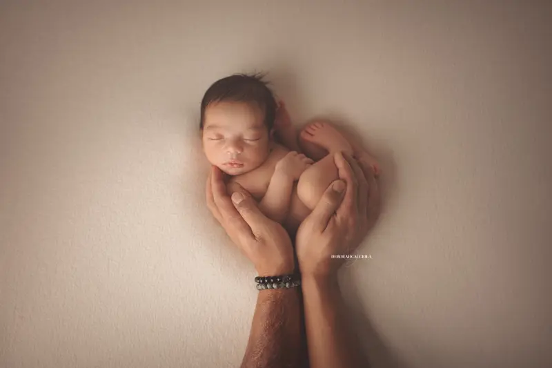 Photo nouveau-né studio Orléans : portrait délicat de bébé, cadrage horizontal équilibré, palette claire