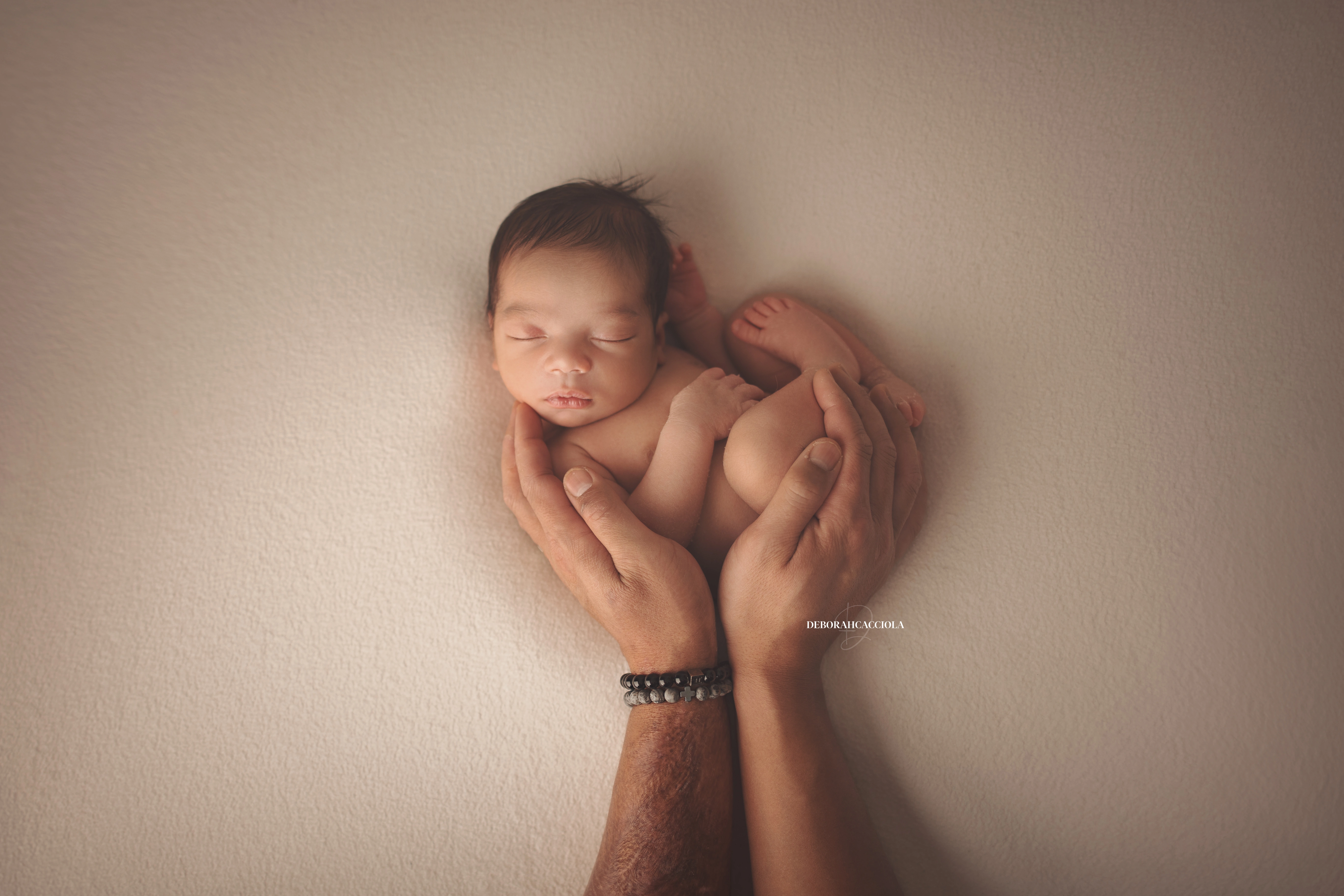 Photo nouveau-né studio Orléans : portrait délicat de bébé, cadrage horizontal équilibré, palette claire