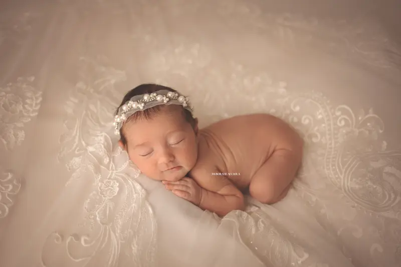 Photo nouveau-né studio Orléans : portrait délicat de bébé, cadrage horizontal équilibré, rendu naturel